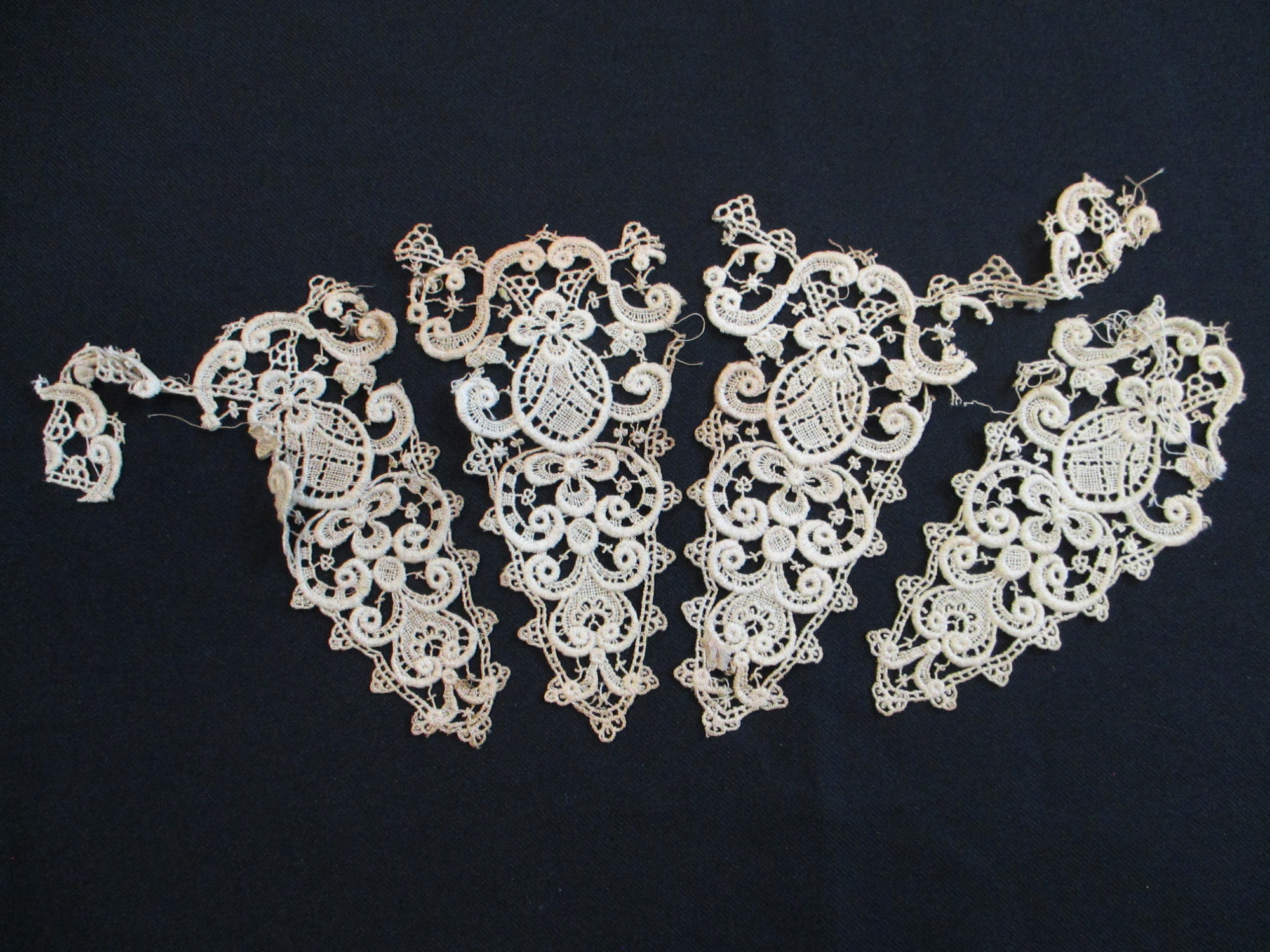 4 triangular pieces of silk lace decoration.