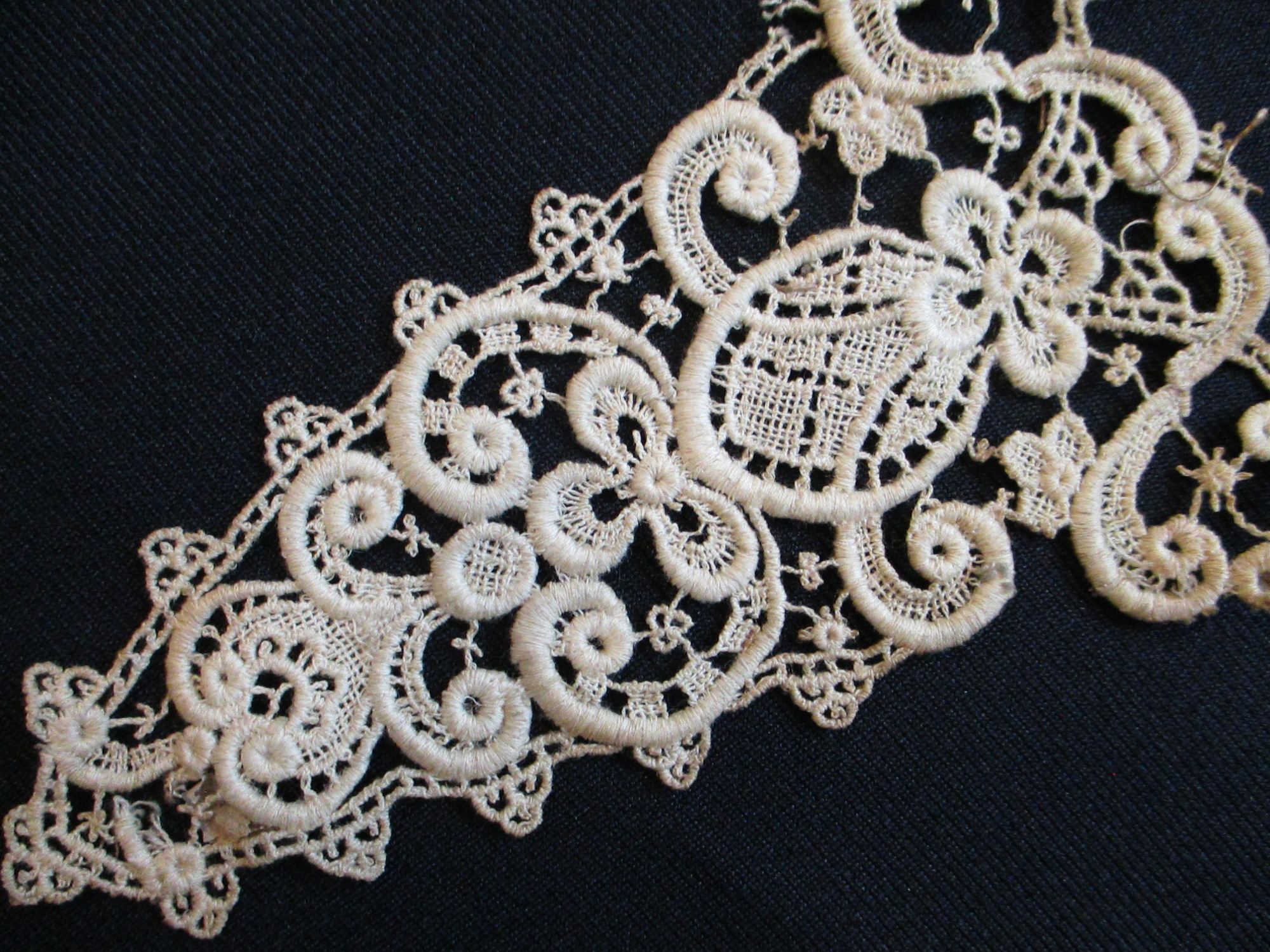 4 triangular pieces of silk lace decoration.: Detail of triangular lace motif.