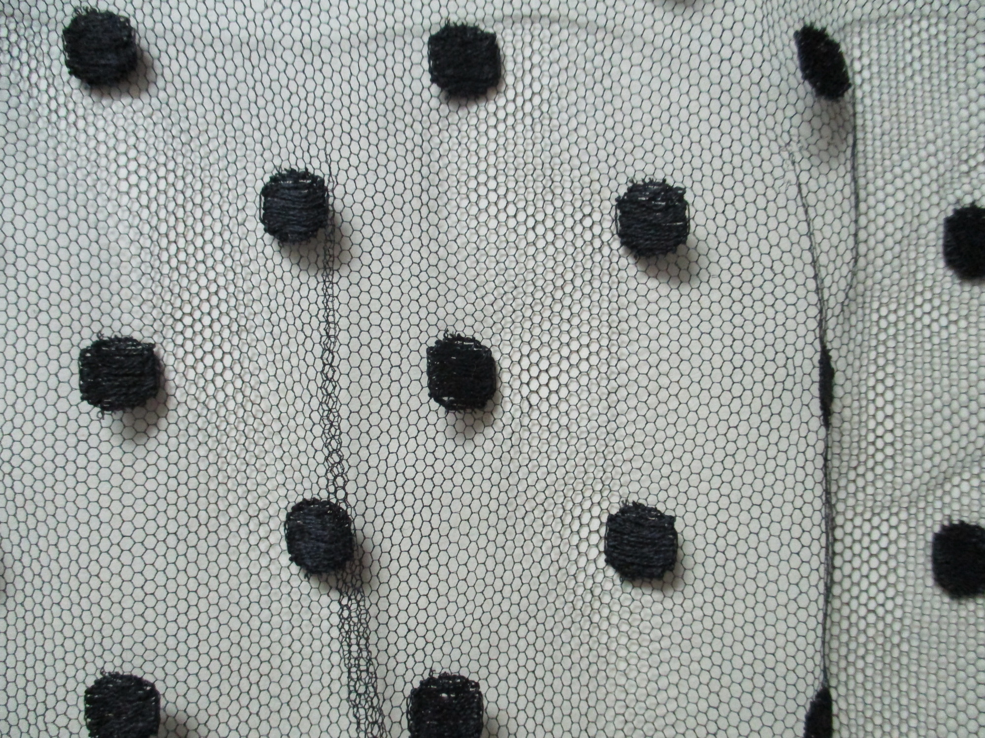 Black lace netting: Close up detail of black spotted netting.