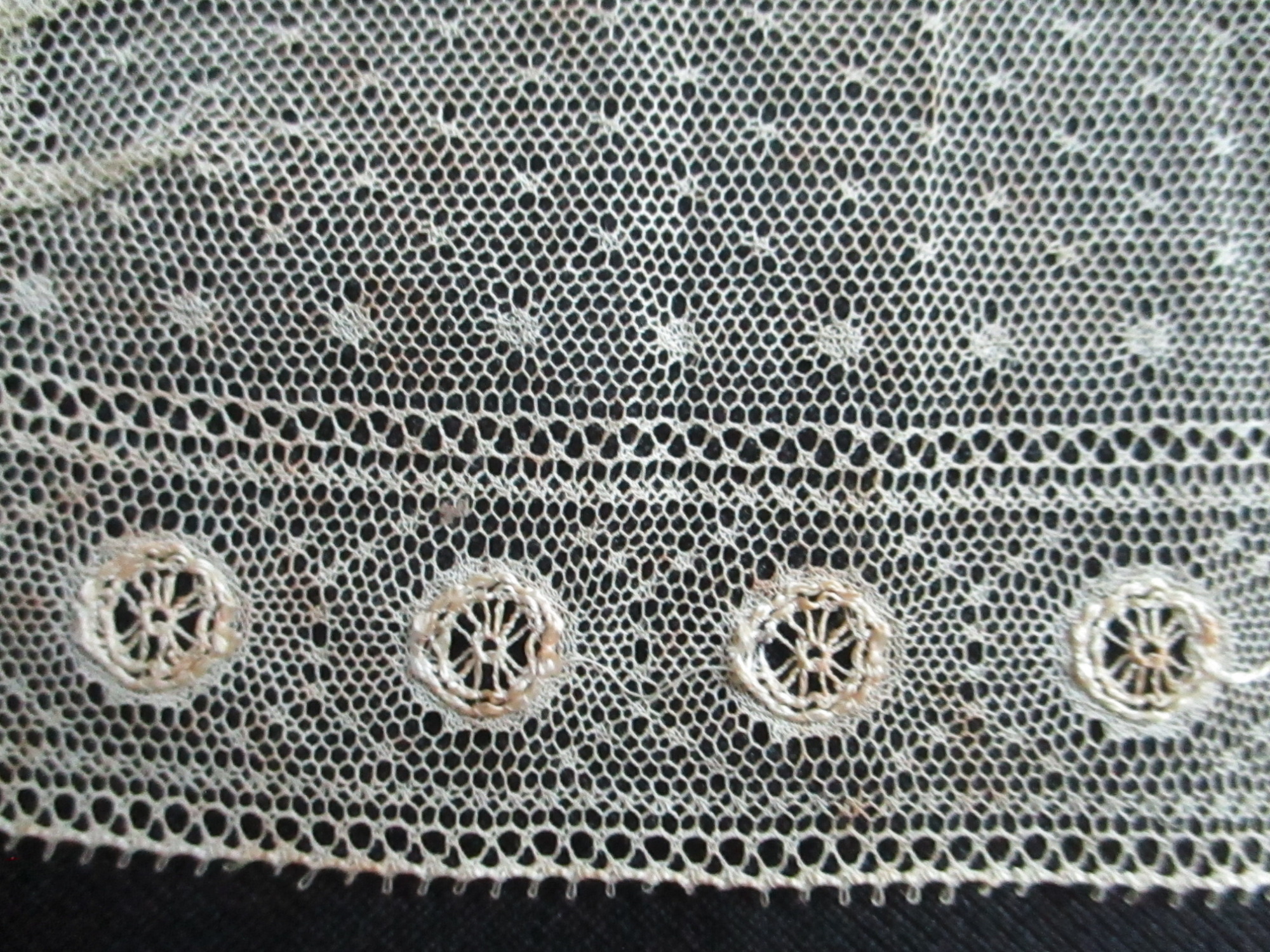 Child's cream collar.: Close-up of embroidered details on child's handmade cream collar.