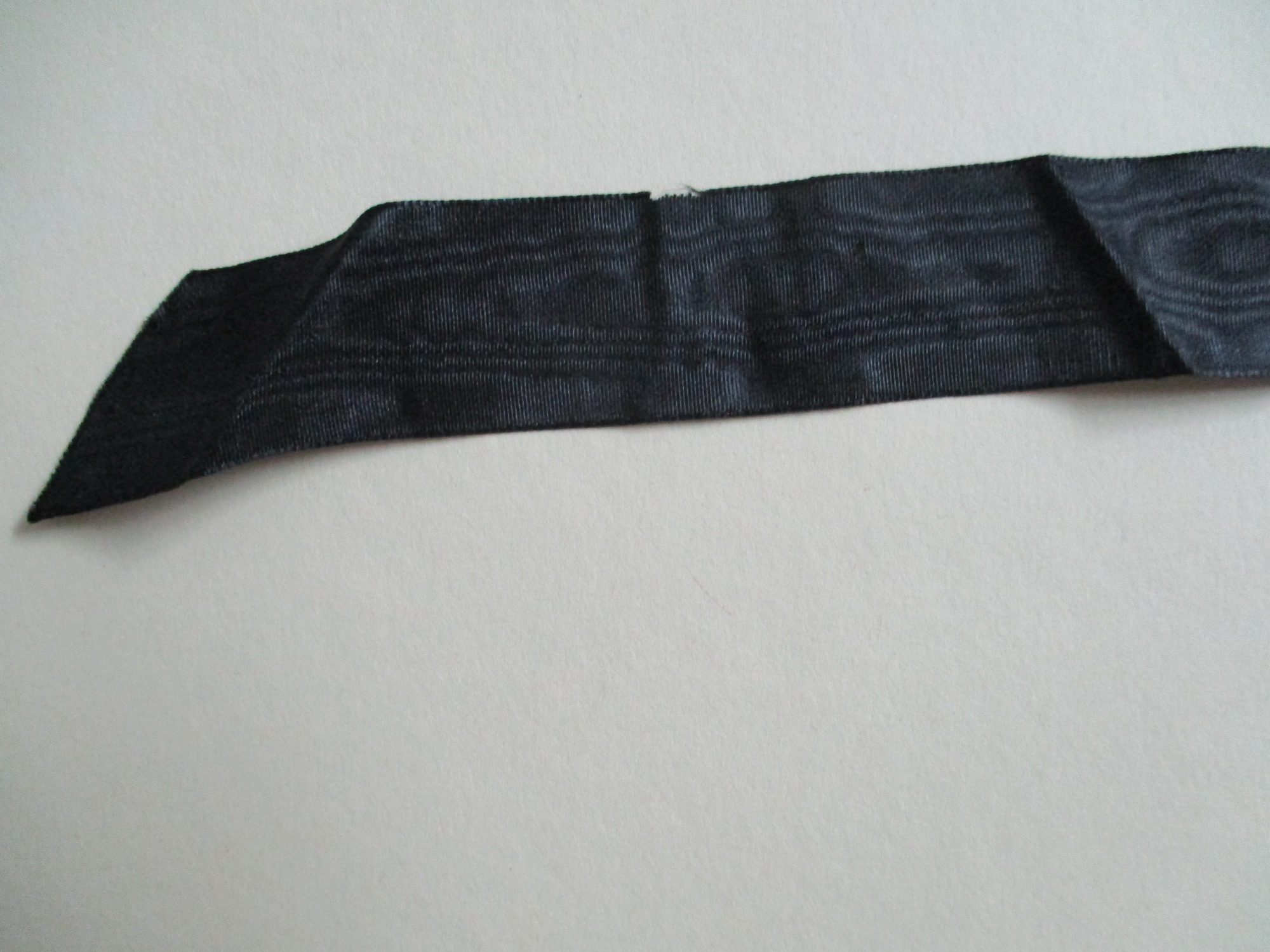 Cream lace collar.: Close up of black satin ribbon.