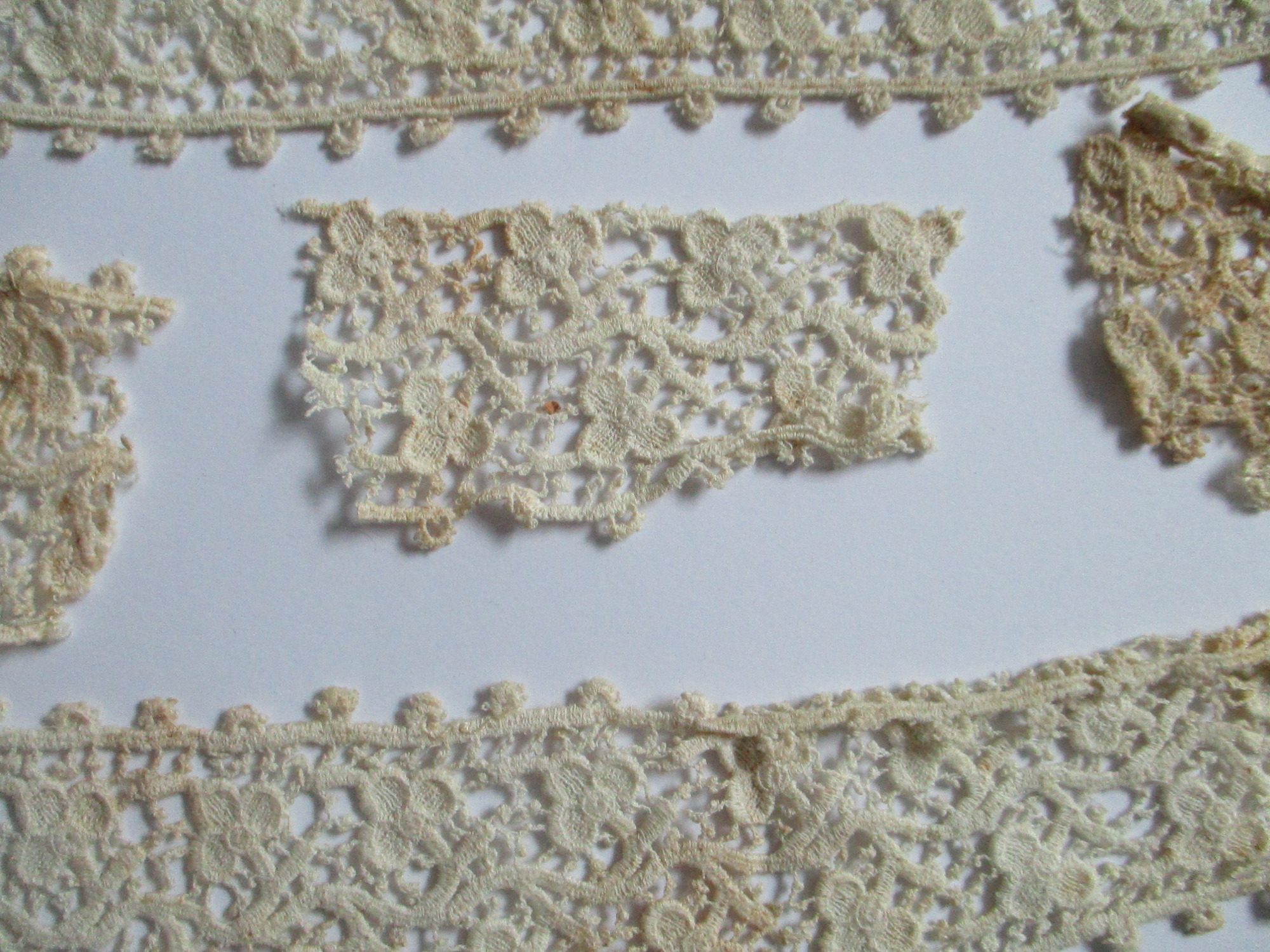 Five pieces of silk lace trim.: Small offcut from piece of silk lace ribbon. (i)