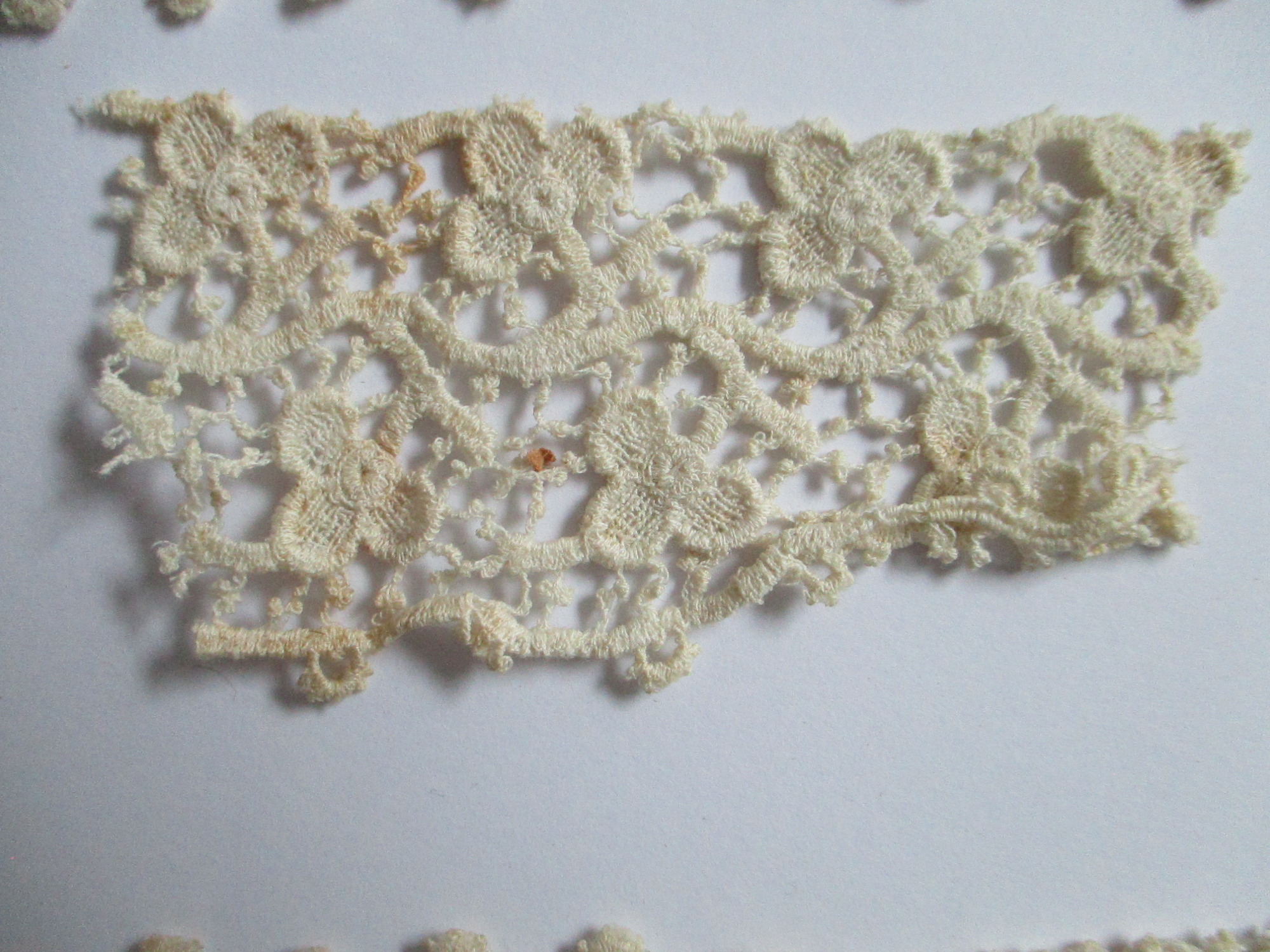 Five pieces of silk lace trim.: Small offcut from piece of silk lace ribbon. (ii)