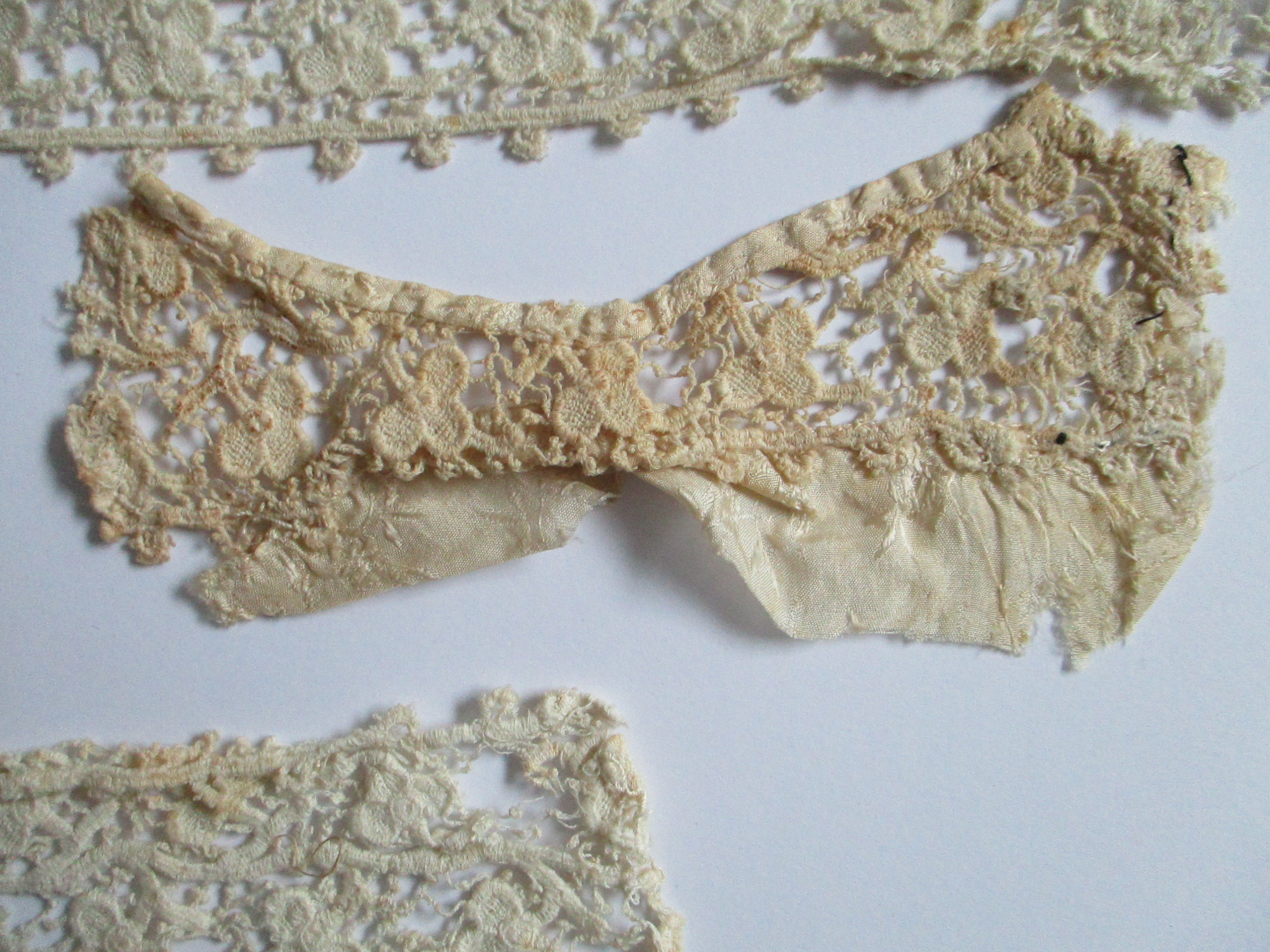 Five pieces of silk lace trim.: Piece of silk lace.