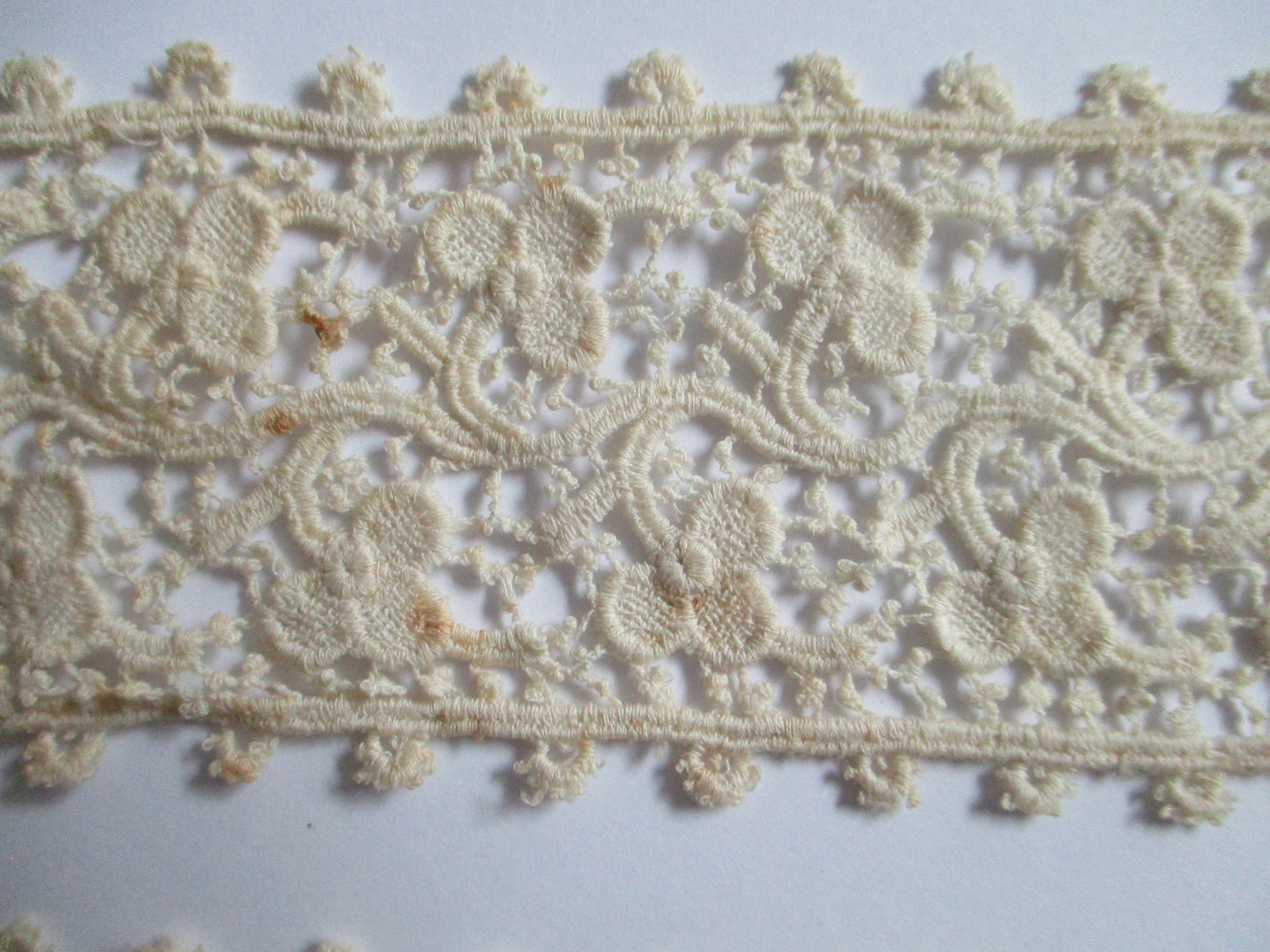 Five pieces of silk lace trim.: Closeup of silk lace ribbon. (i)
