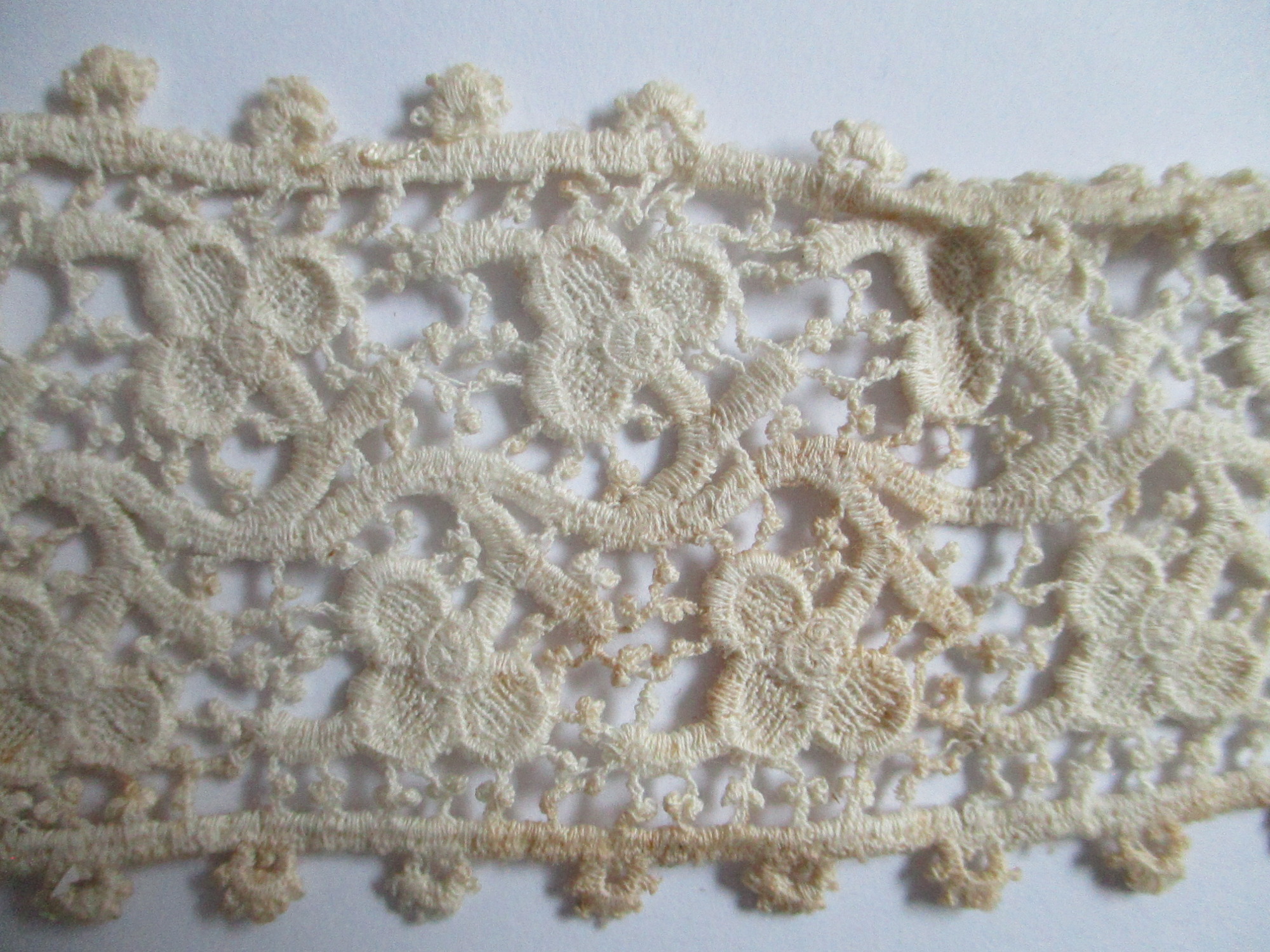Five pieces of silk lace trim.: Closeup of silk lace ribbon. (ii)
