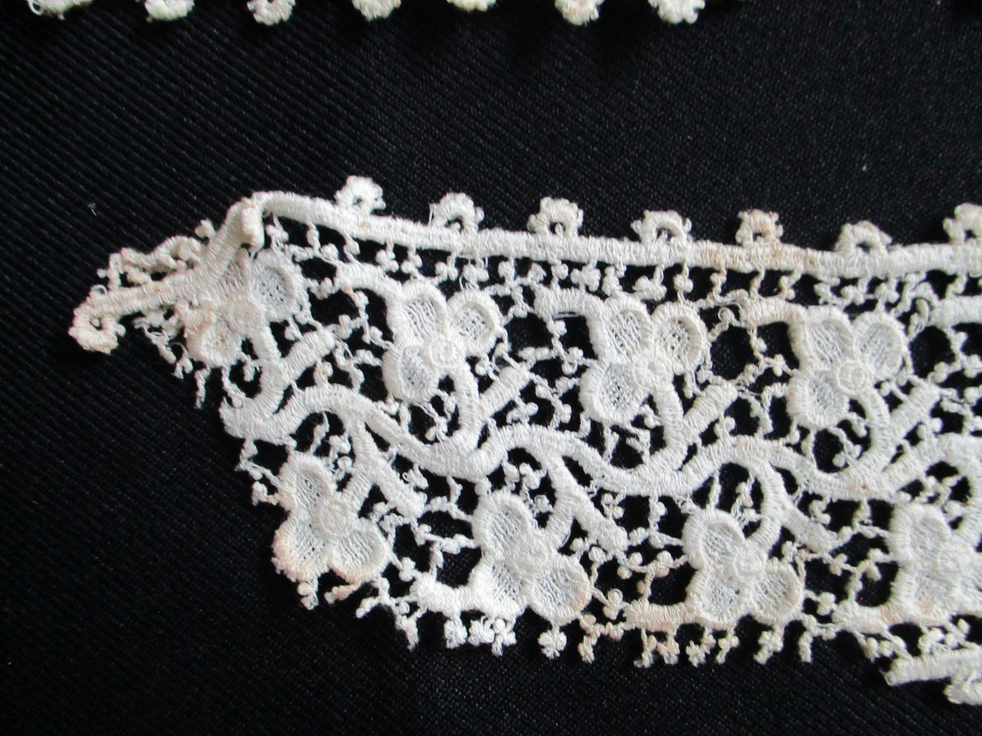 Five pieces of silk lace trim.: Closeup of silk lace ribbon. (ii)