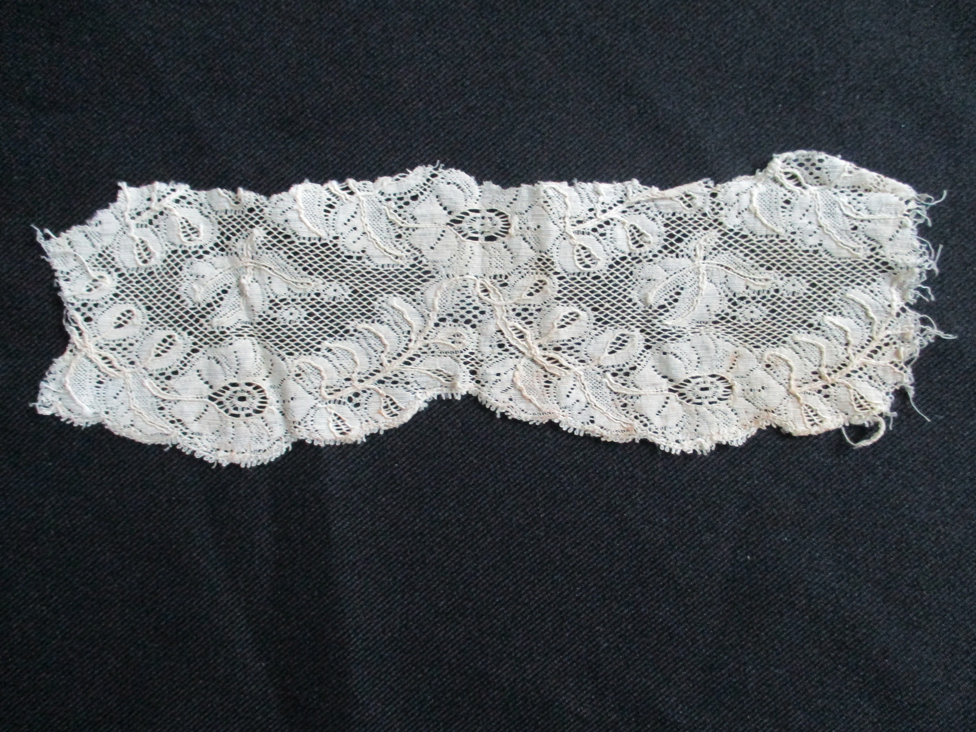 Four pieces of cream lace.: Small piece of cream silk lace showing flower detail.