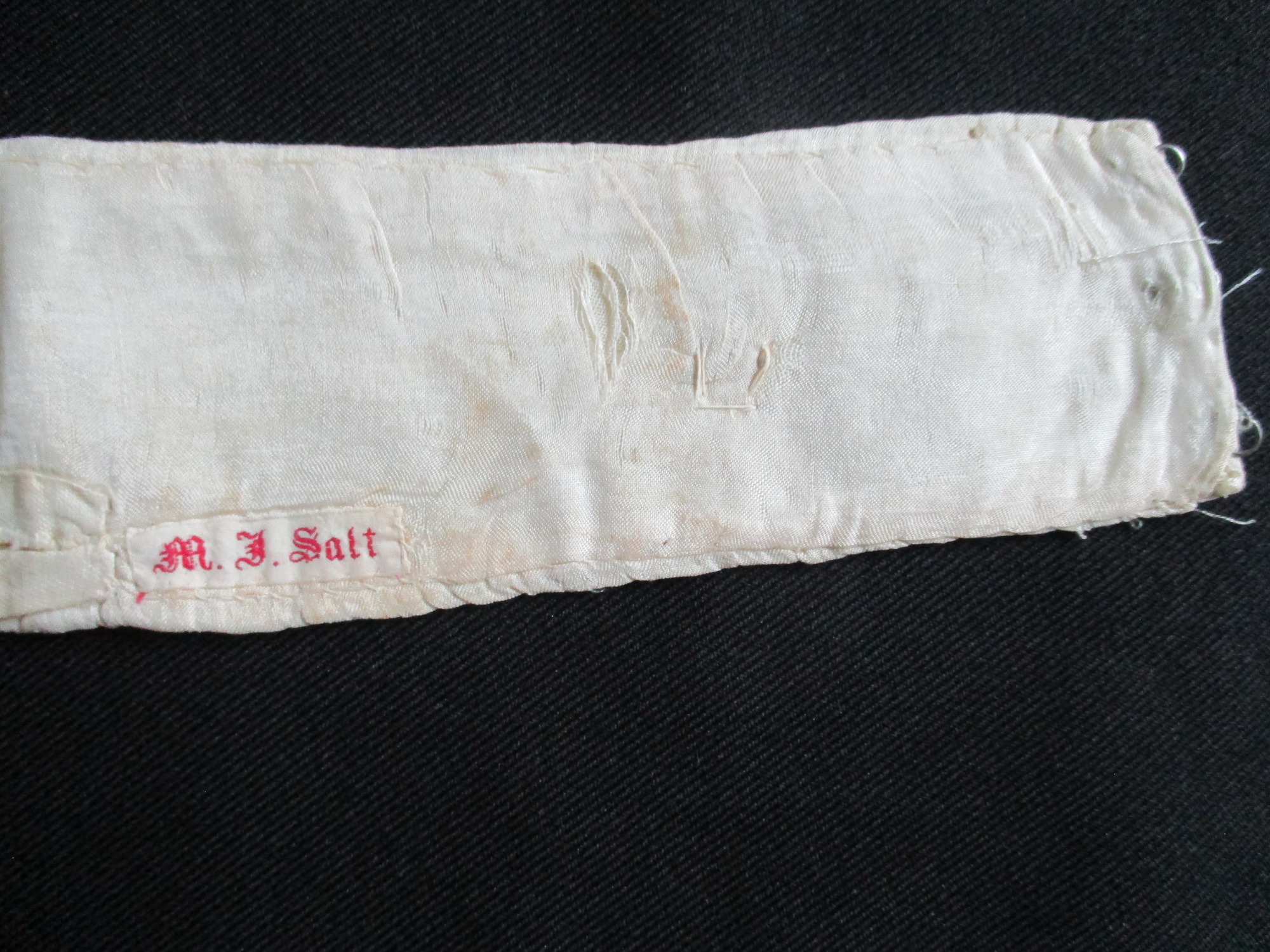 Lace Collar: Close up of owners name tag on silk collar interface.