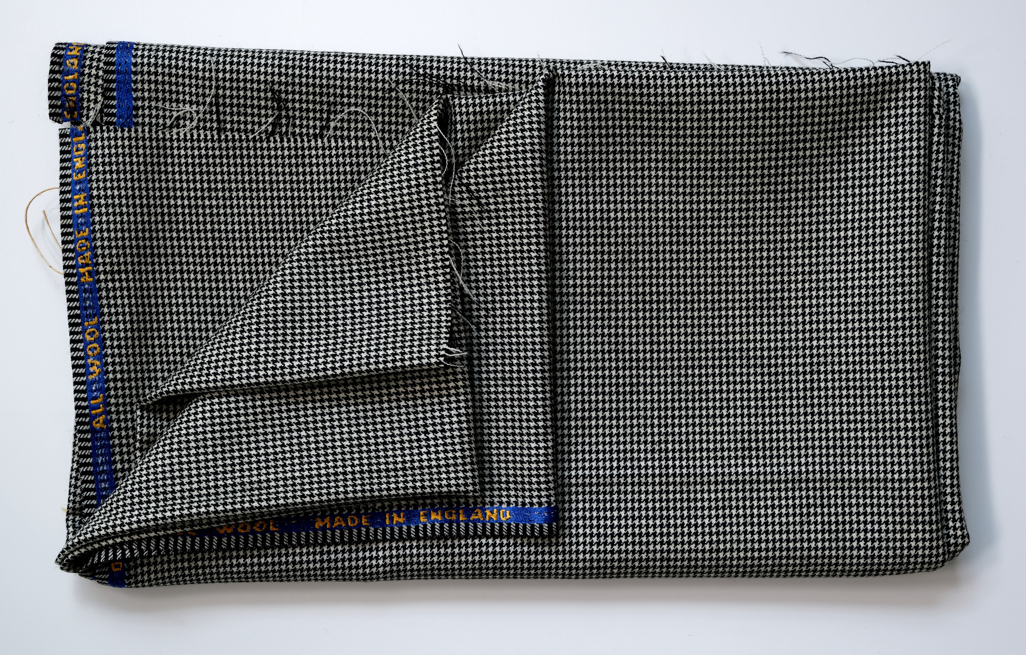 Length of dogtooth-pattern all-wool cloth: View showing cloth folded back twice