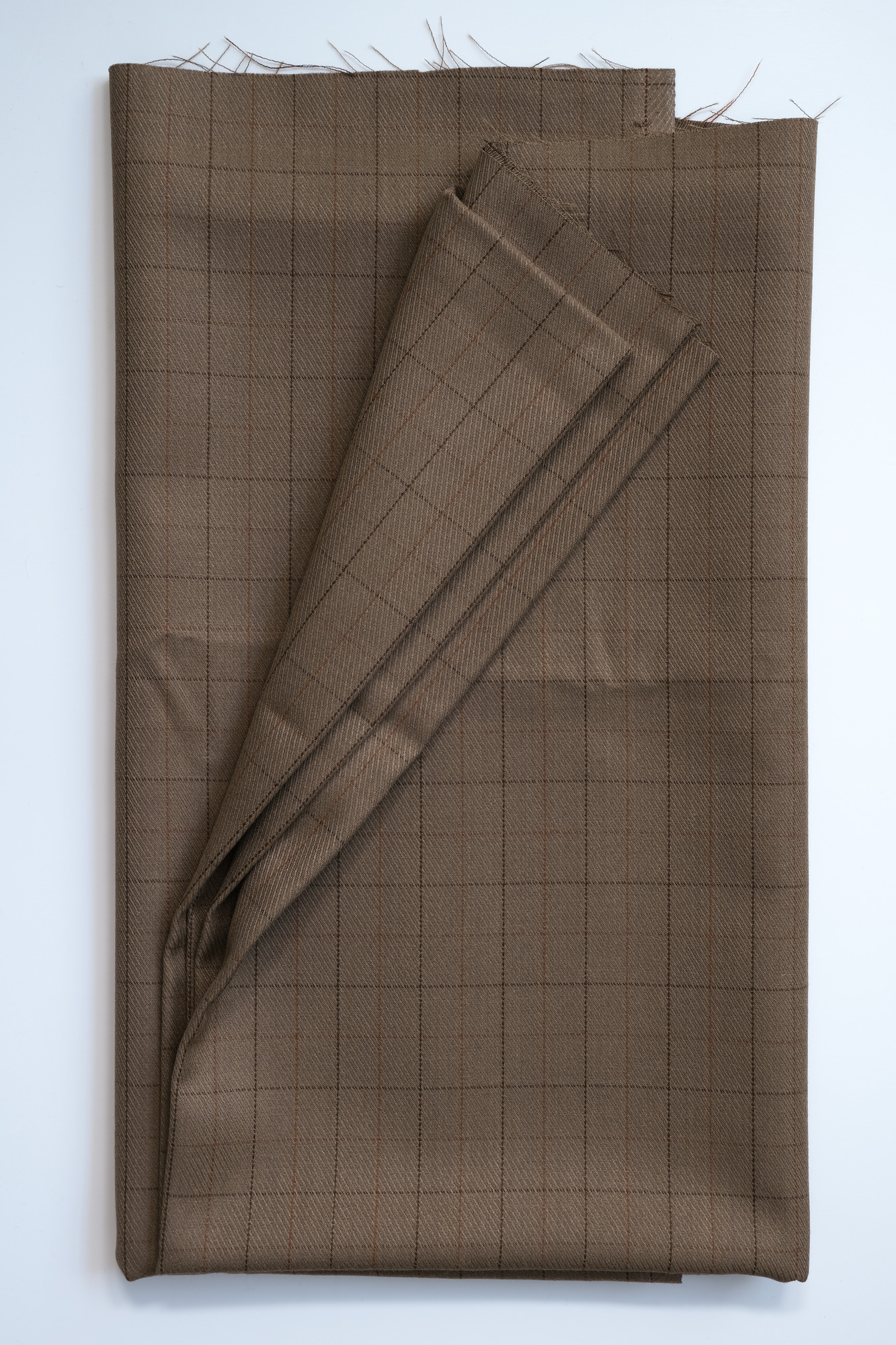 Length of light-brown slight-check cloth: View showing cloth folded back thrice