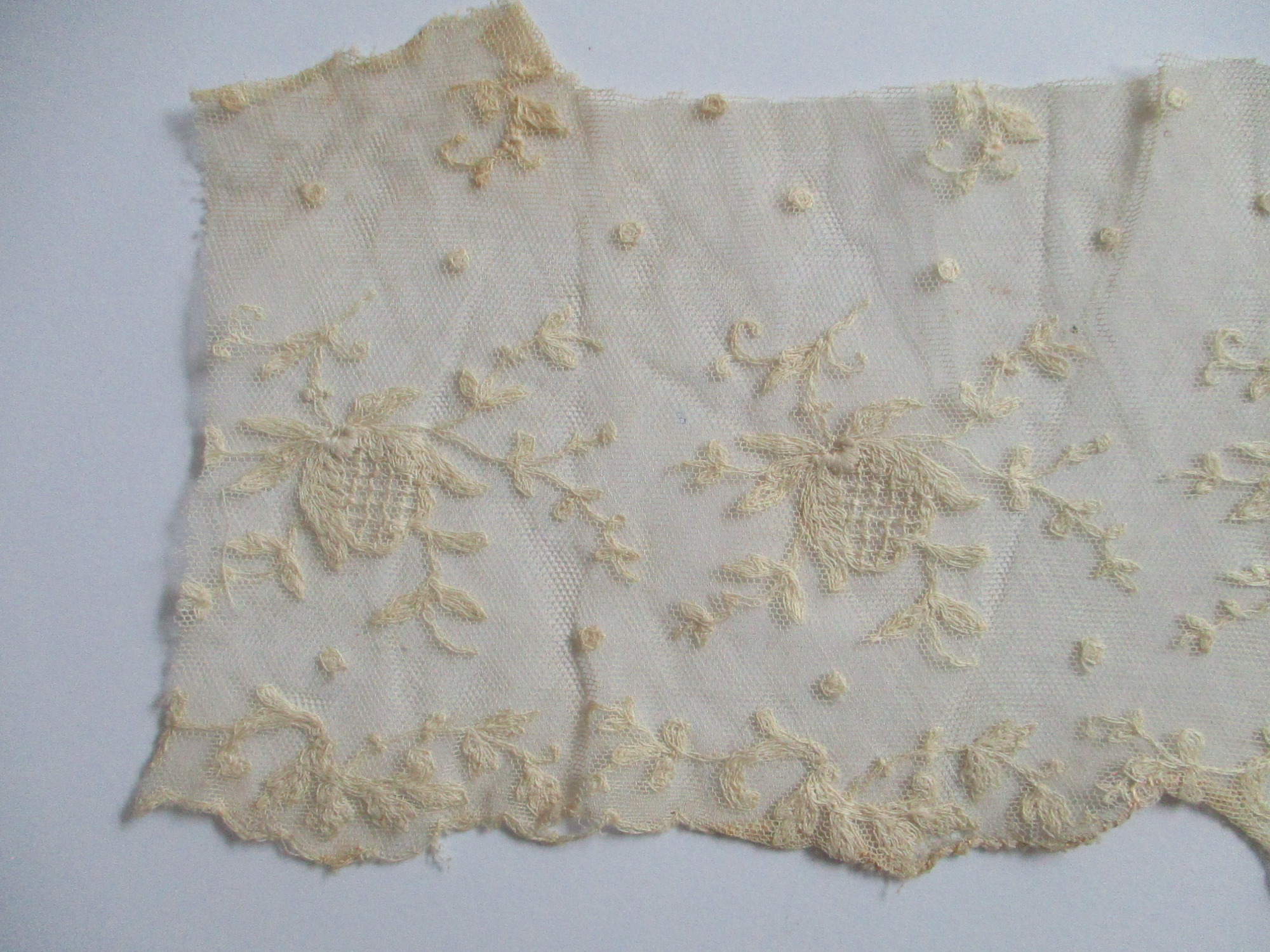 Piece of cream silk embroidered netting.: Close up of lace netting showing embroidered design. (iii0