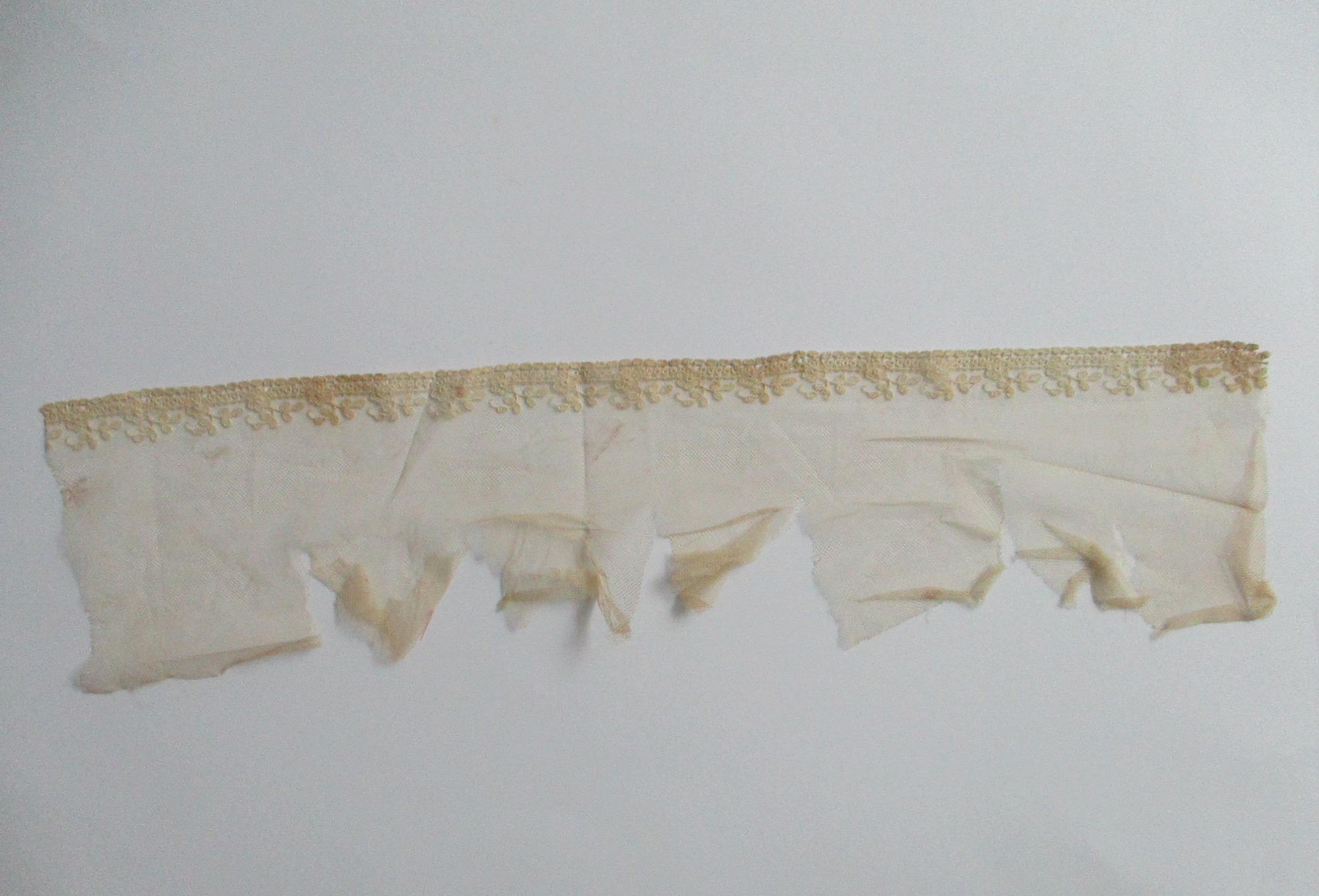 Piece of decorated nylon netting.: Piece of decorated cream netting. (ii)