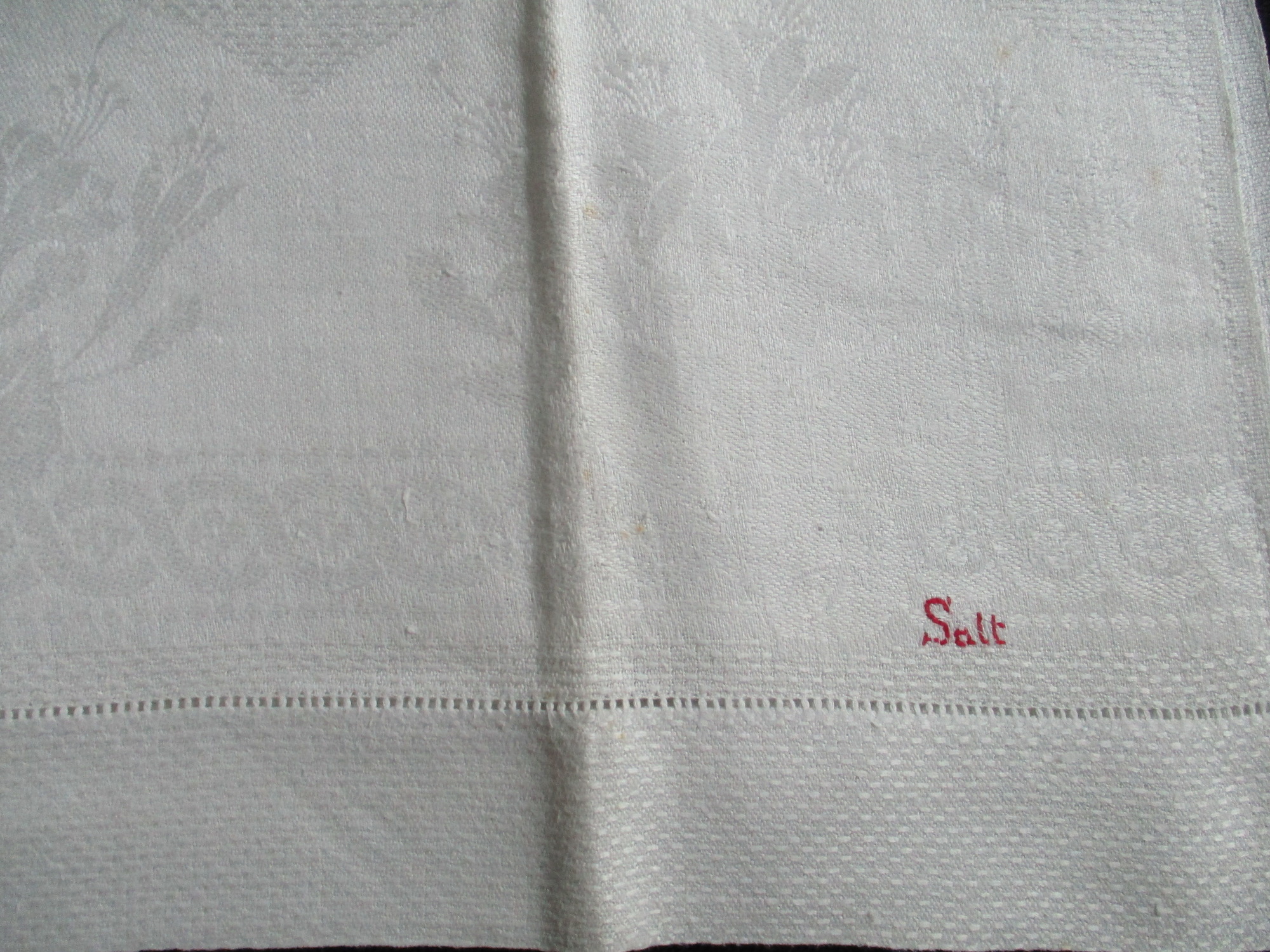 Seven cream damask towels.: Close up of Salt mongram