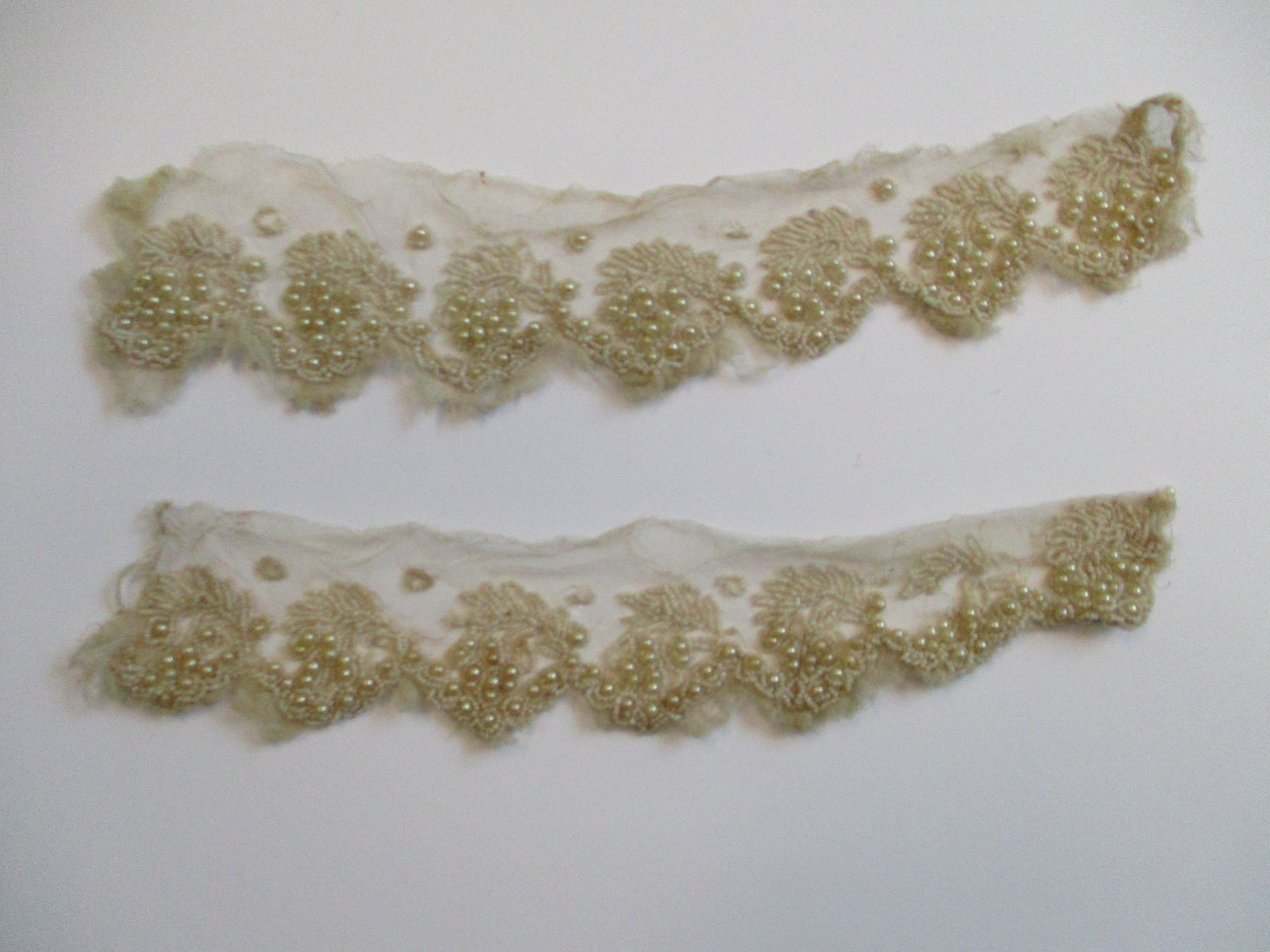 Strips of heavily beaded cream netting