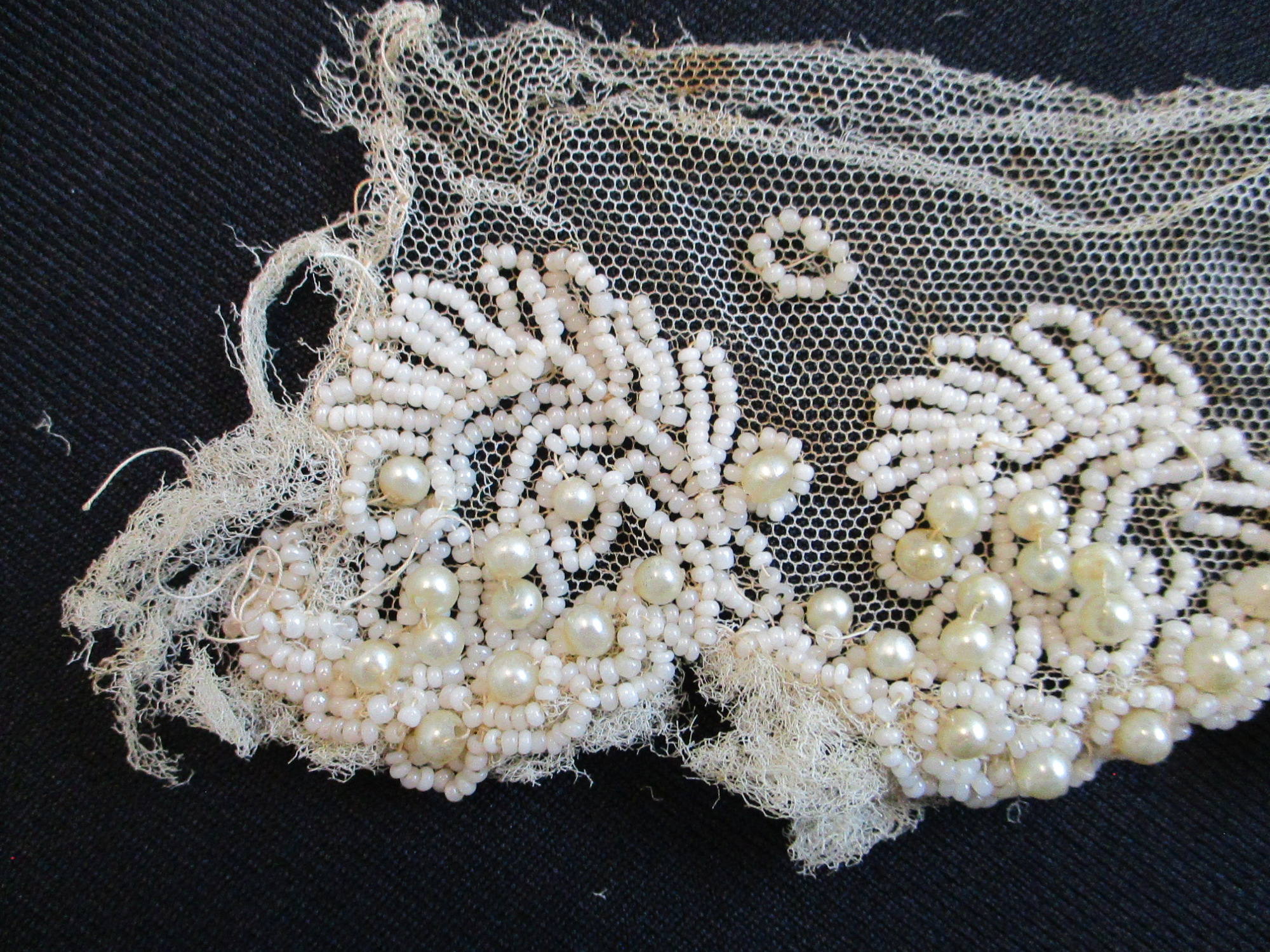 Strips of heavily beaded cream netting: Beading detail on cream netting. (ii)