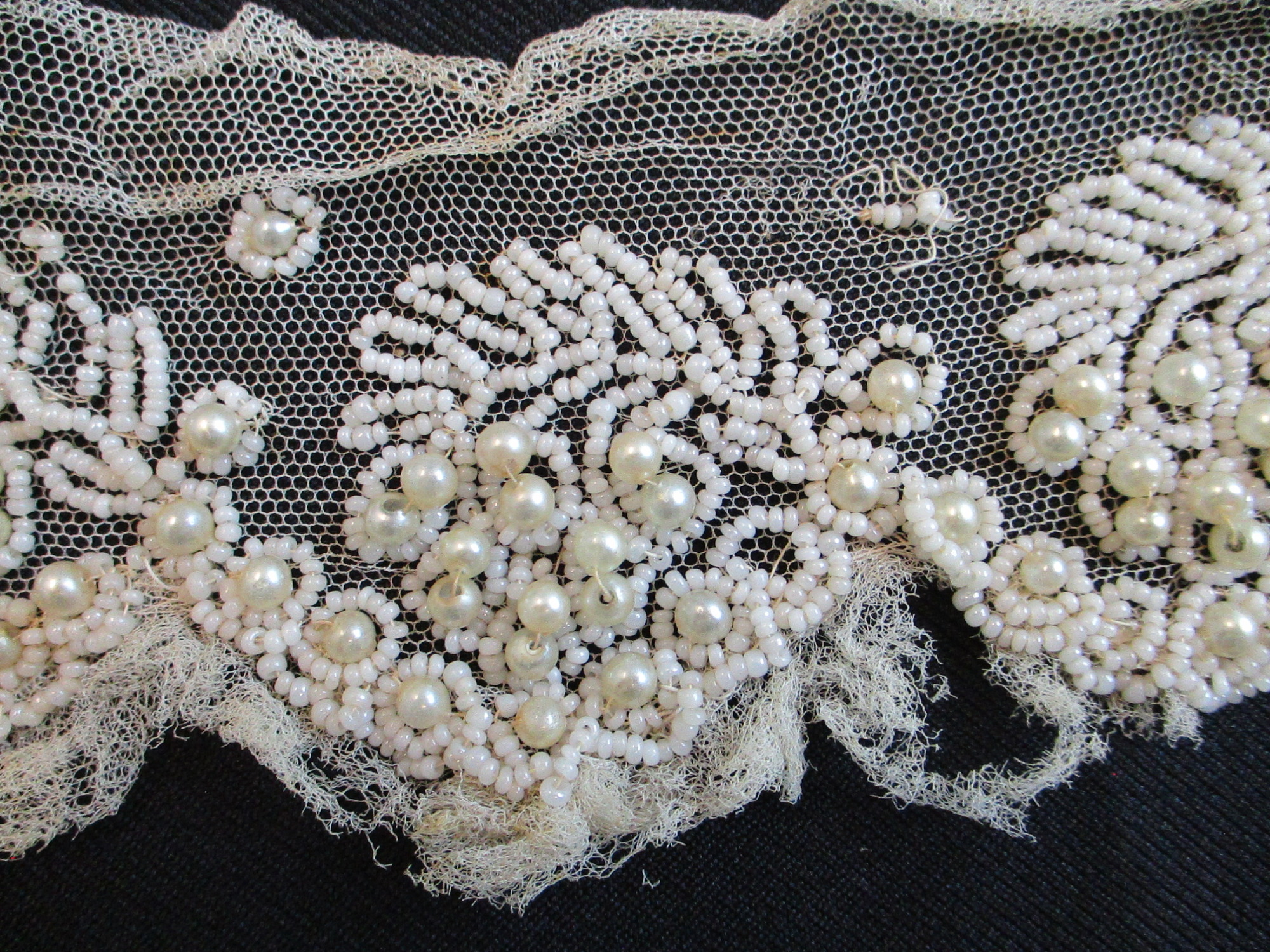 Strips of heavily beaded cream netting: Beading detail on cream netting. (iv)