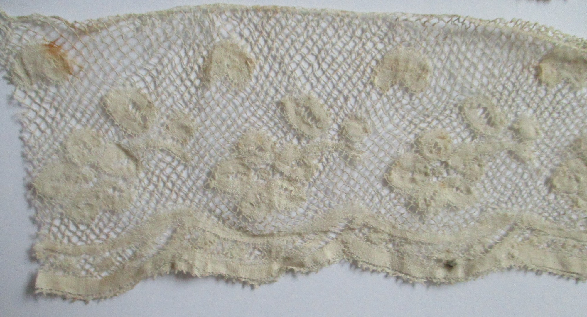 Three pieces of cream silk lace trim.: Design detail of cream silk lace trim. (i)