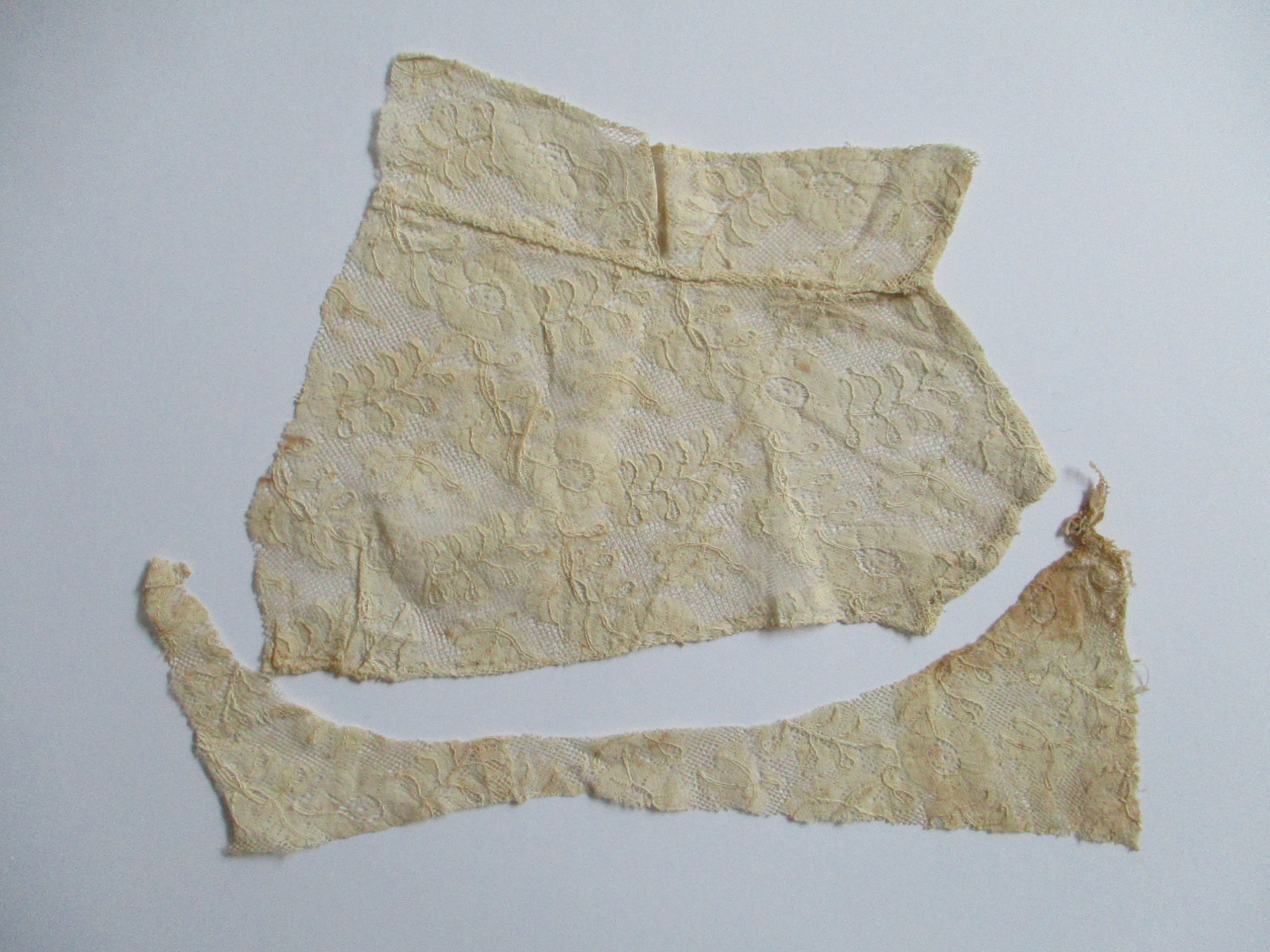 Two pieces of cream silk lace.: Two pieces of cream silk lace cut from collar/bib. (ii)