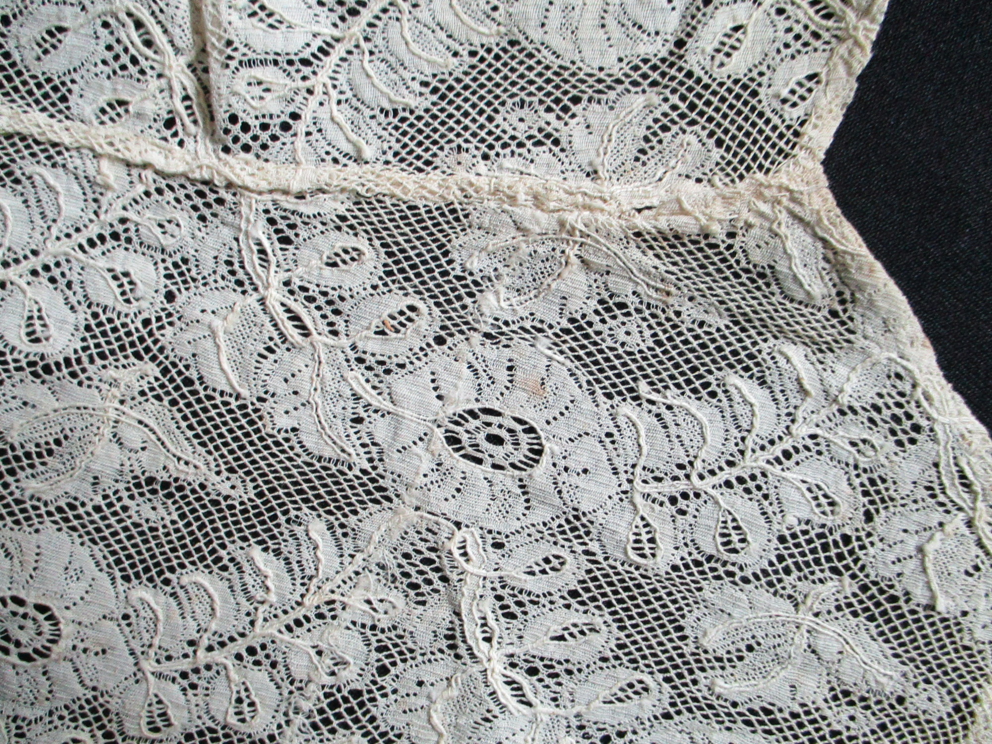Two pieces of cream silk lace.: Design detail on cream silk lace cut from collar/bib. (i)