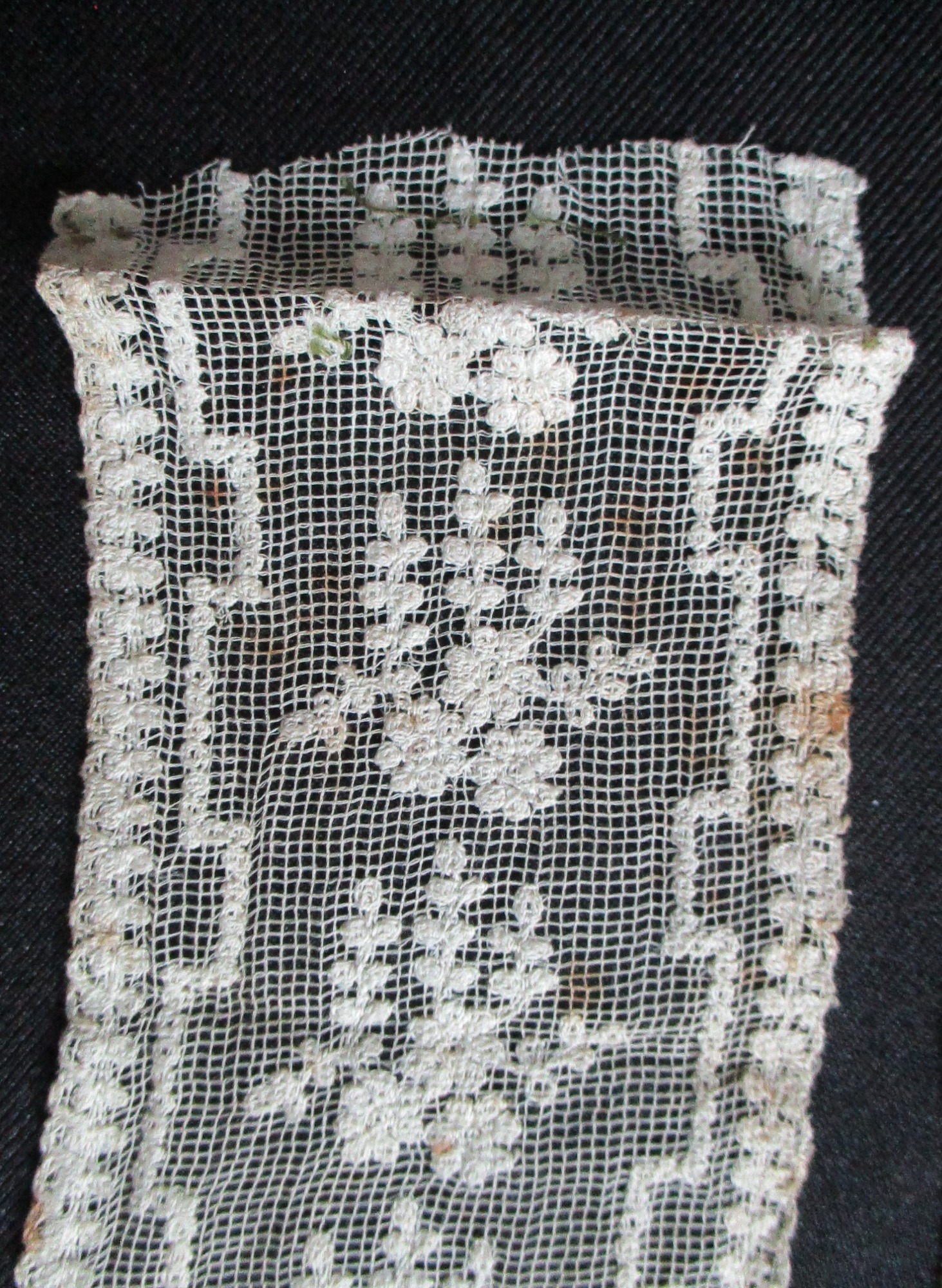 Two pieces of decorated cream netting.: Folded end of cream lace ribbon. (ii)