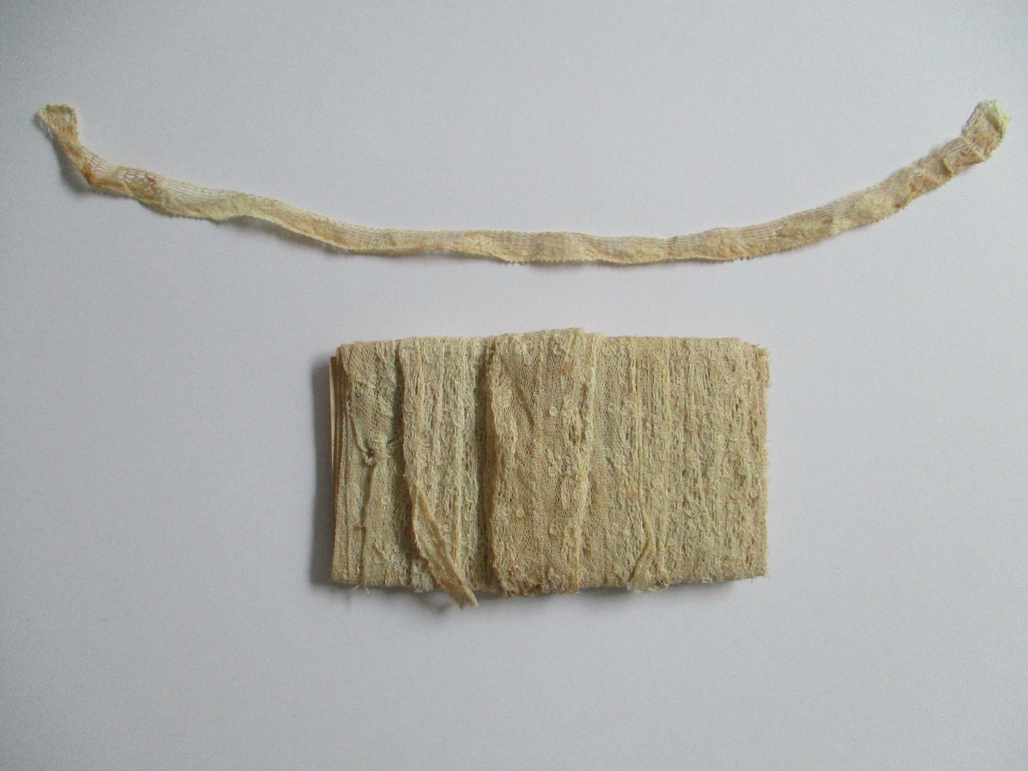 Unused length of lace trim/ribbon wound round paper.